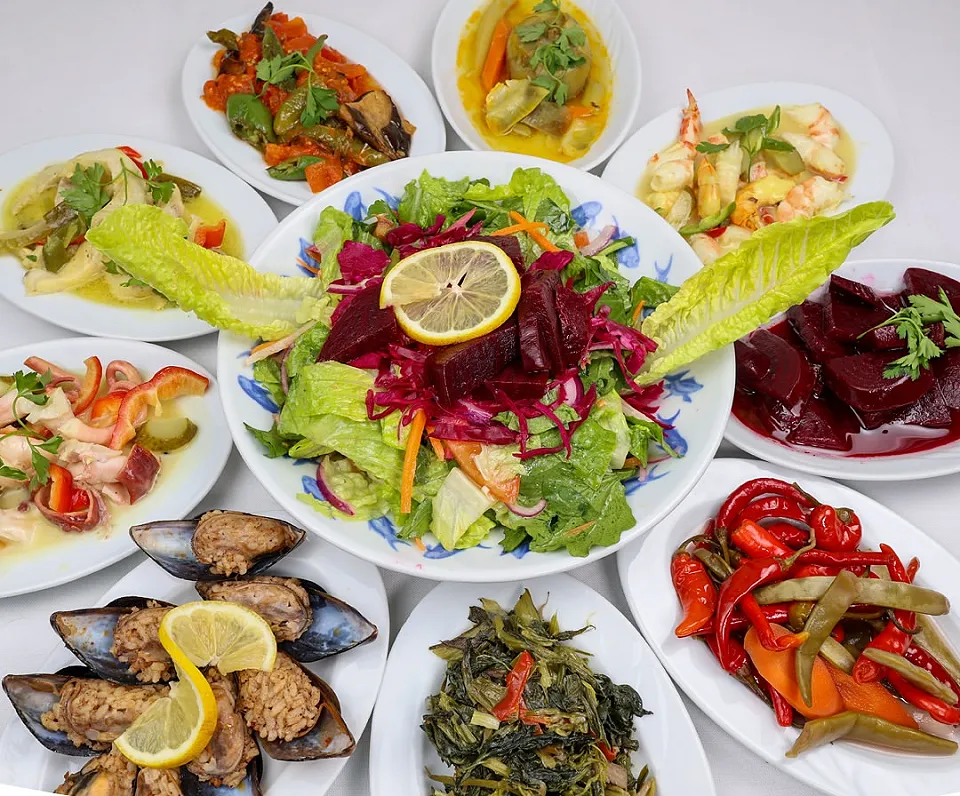 A meze spread with stuffed mussels, beetroot, roasted peppers, wild greens in olive oil and a colourful salad in the middle