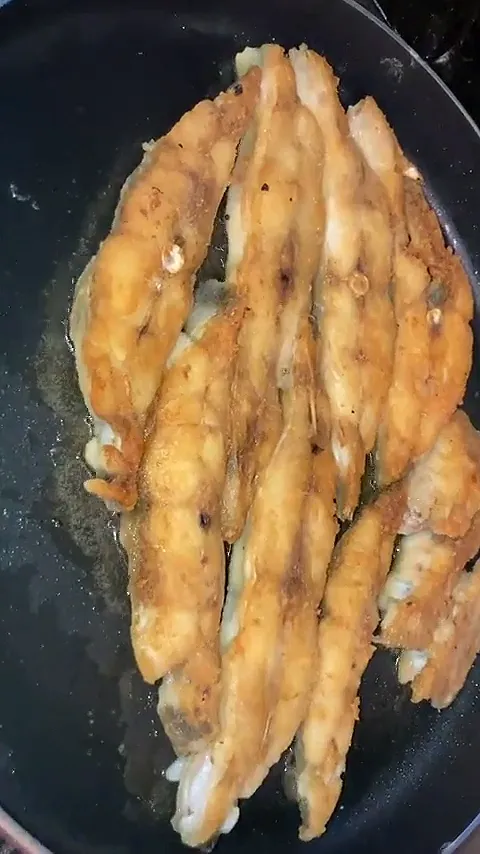 Video: flour-dusted fish fillets frying in a black pan until golden