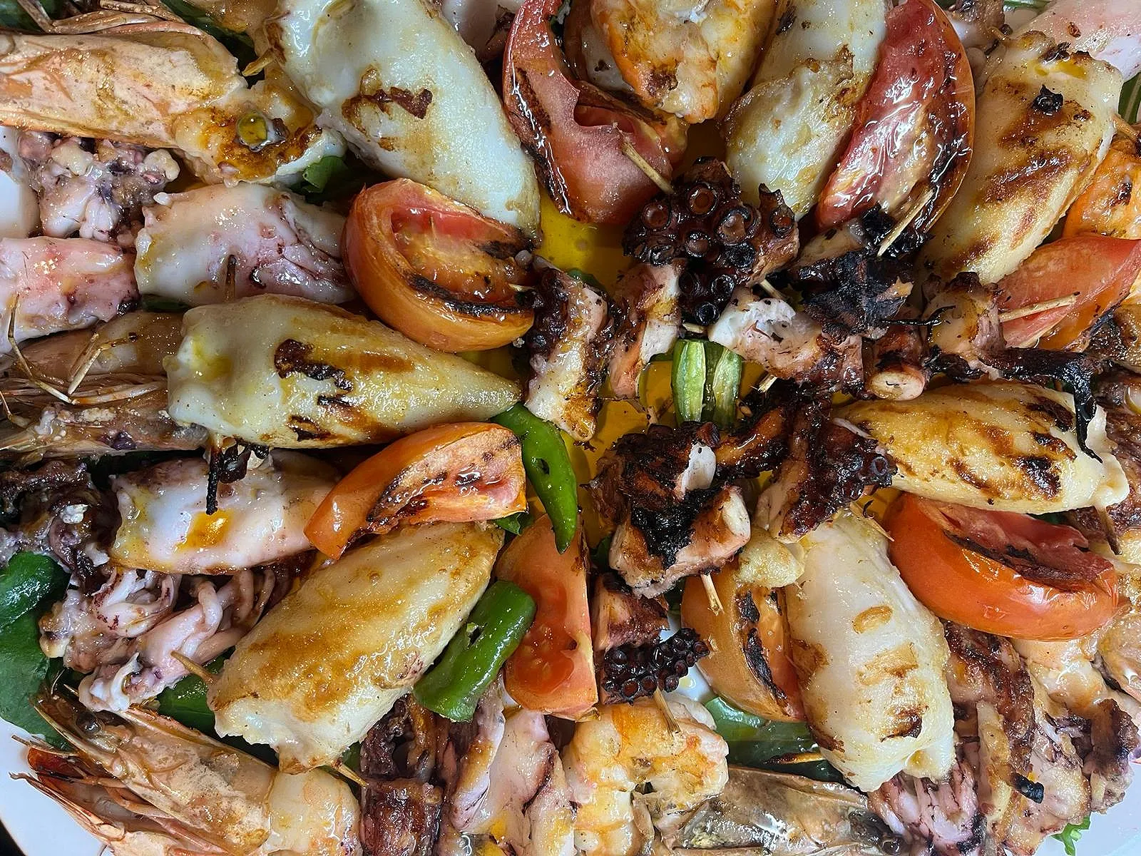 Mixed grill platter of calamari, octopus and prawns with roasted tomatoes and green peppers