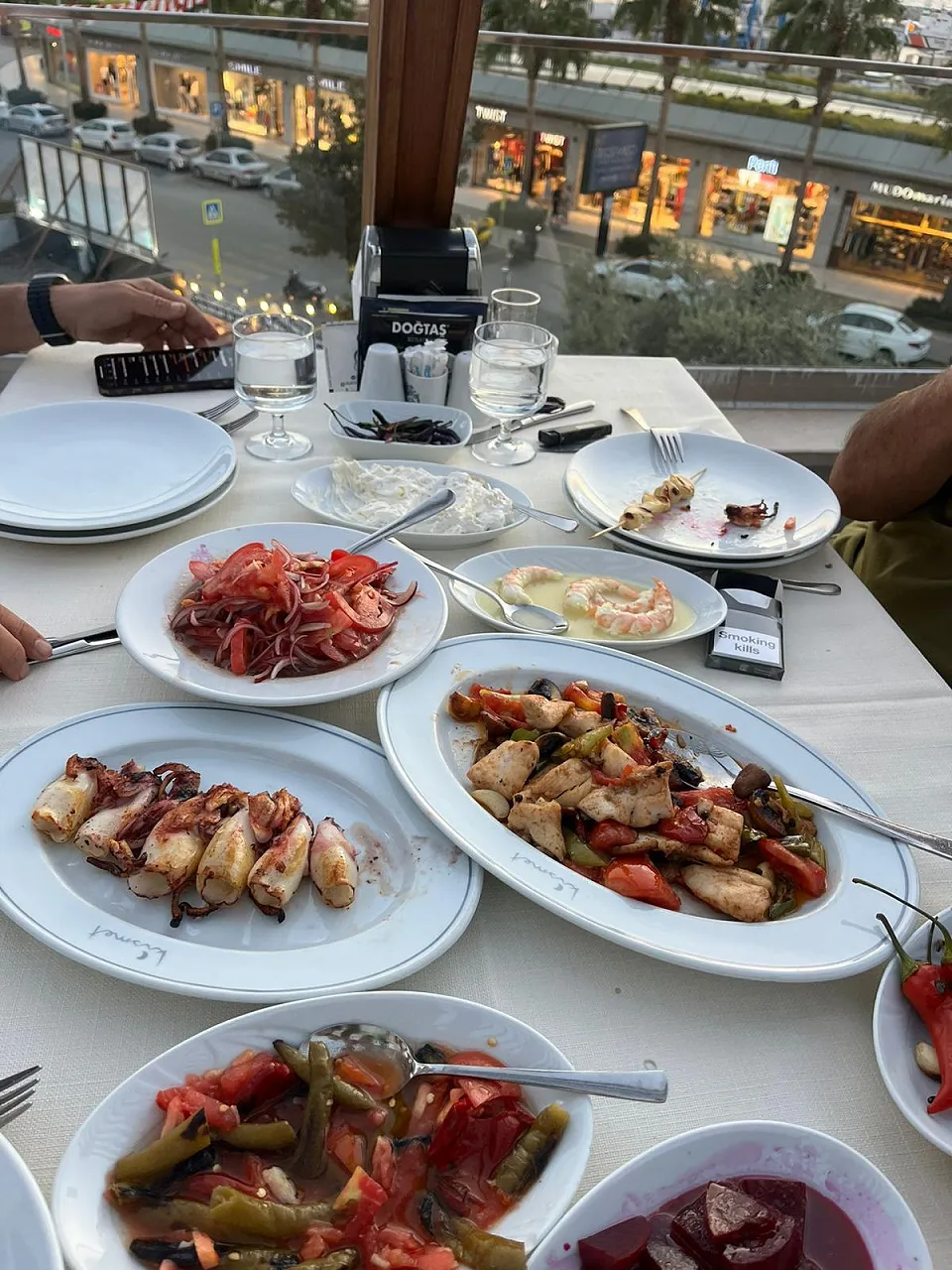 A table overlooking the boulevard with grilled calamari, prawns in butter, a sauté and peppers with tomato
