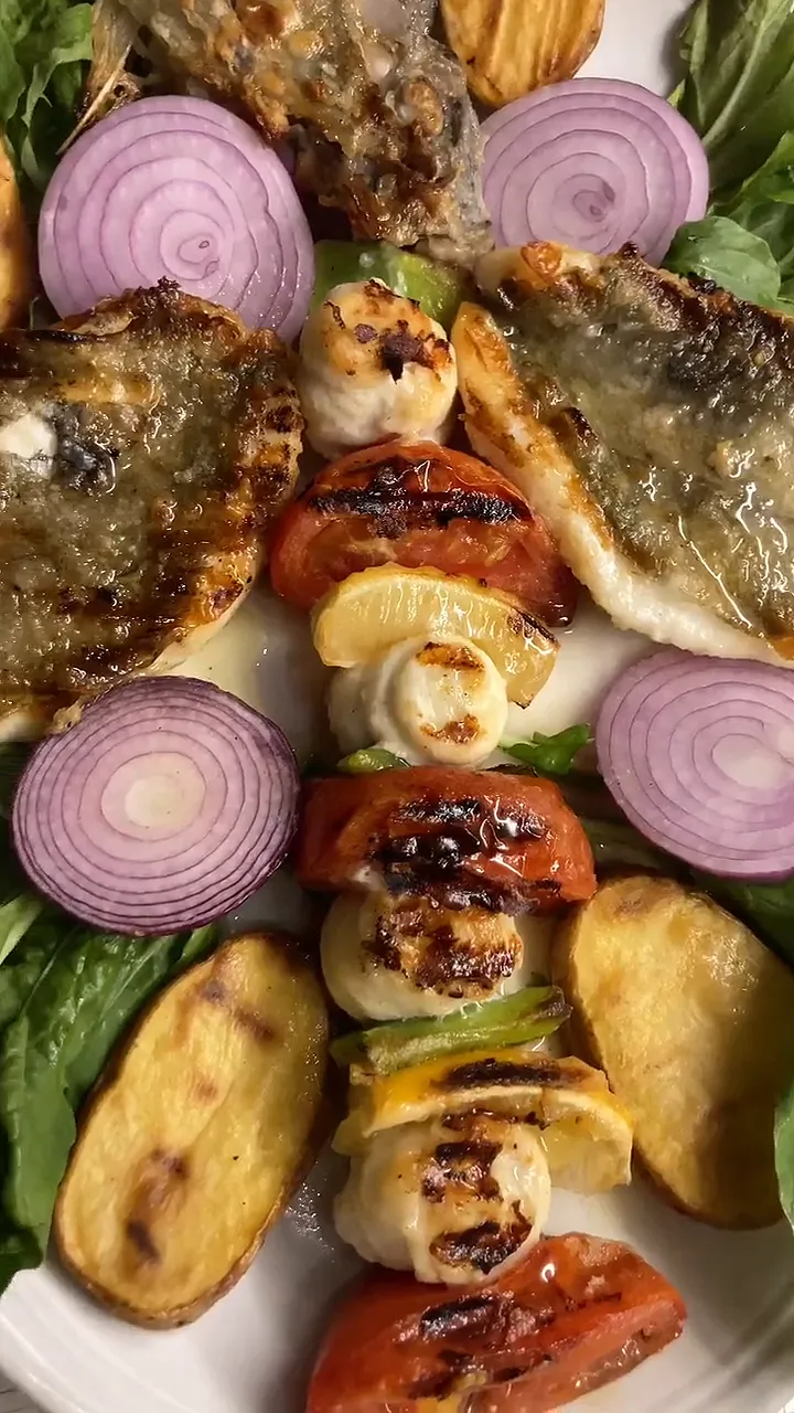 Video: grilled fish fillets, a skewer with tomato and lemon, potatoes and red onion rings